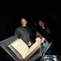 Dirk en Annelynn bespreken het hanteren van grootformaat handschriften. Den Haag, KB, KW 78 A 30.