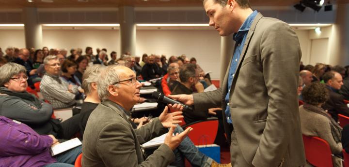 De dagvoorzitter Ruben Maes in gesprek met het publiek